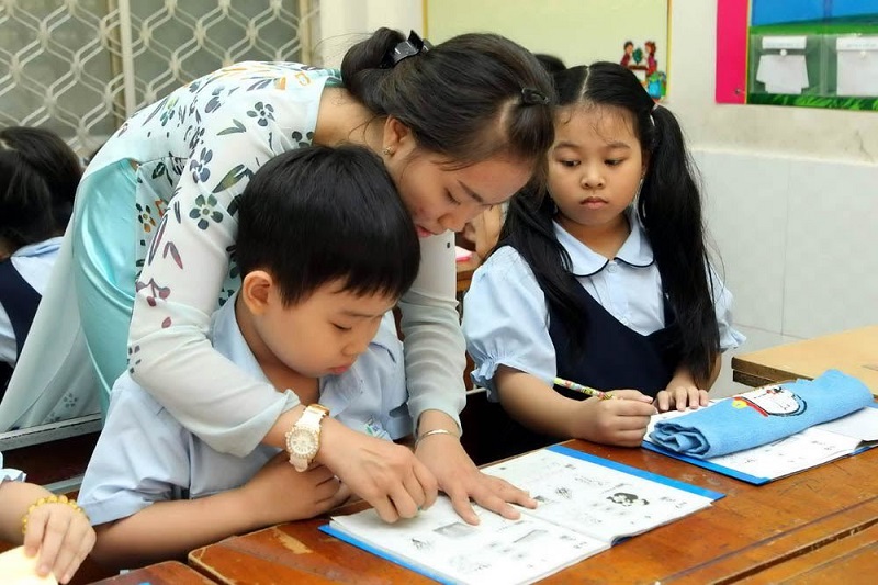 Cô giáo kèm bé học tại lớp. (Ảnh: Vietnamnet.vn)
